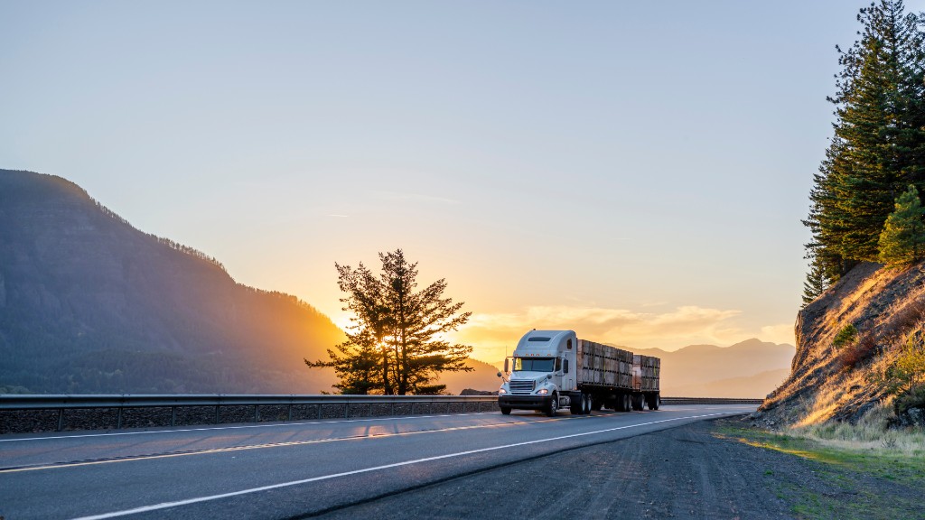 Semi-truck with trailer on a highway at sunset